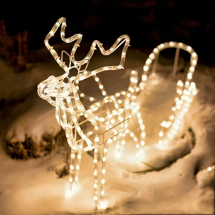 Tween Light LED-Lichtschlauch Rentier mit Schlitten - Anwendungsbereich: Außen, Warmweiß - Beleuchtete warmweiße LED-Rentier- und Schlittendekoration steht nachts im Schnee.