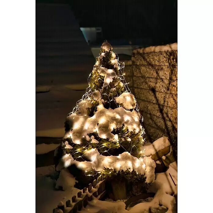 Tween Light LED-Lichtnetz - Außen, 2 m, Lichtfarbe: Warmweiß, Netzbetrieben - Ein kleiner, verschneiter immergrüner Weihnachtsbaum, geschmückt mit warmweißen Lichterketten, nachts draußen stehend.