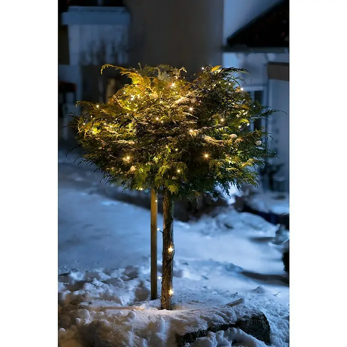 Tween Light LED-Lichterkette - Außen, Lichtfarbe: Warmweiß, Anzahl Leuchtmittel: 200 Stk., Netzbetrieben, 35 m - Ein dekorativer, runder Baum im Schnee ist mit warmweißen Lichtern geschmückt, die eine festliche Atmosphäre erzeugen.