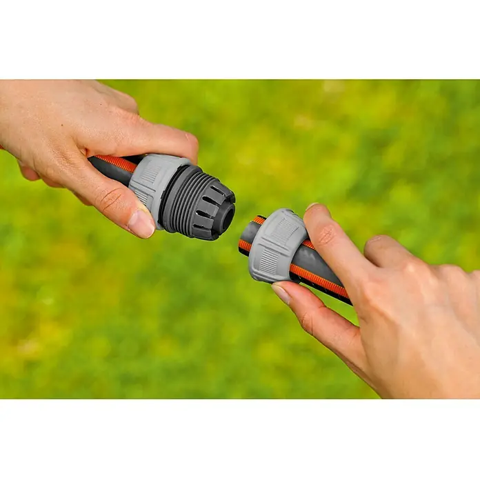 Gardena Reparador de manguera - Diámetro: 19 mm, Plástico - La imagen muestra dos manos conectando un conector de manguera Gardena. Práctico accesorio de jardín para facilitar el riego.