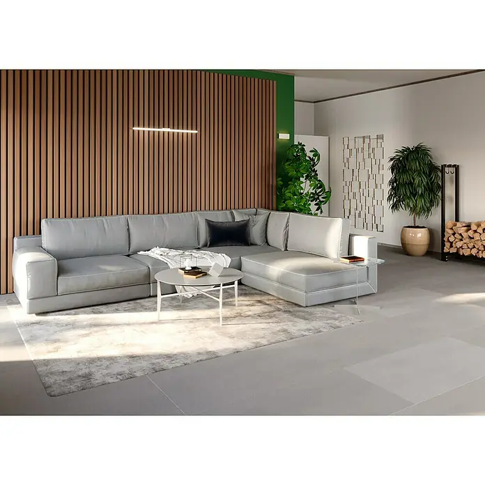 Ambiente by Palazzo Feinsteinzeugfliese - 60 x 120 cm, Grau, Matt - Helles Wohnzimmer mit grauem Sofa, Holzwand und Akzentpflanzen. Der Raum strahlt moderne Eleganz und Gemütlichkeit aus.