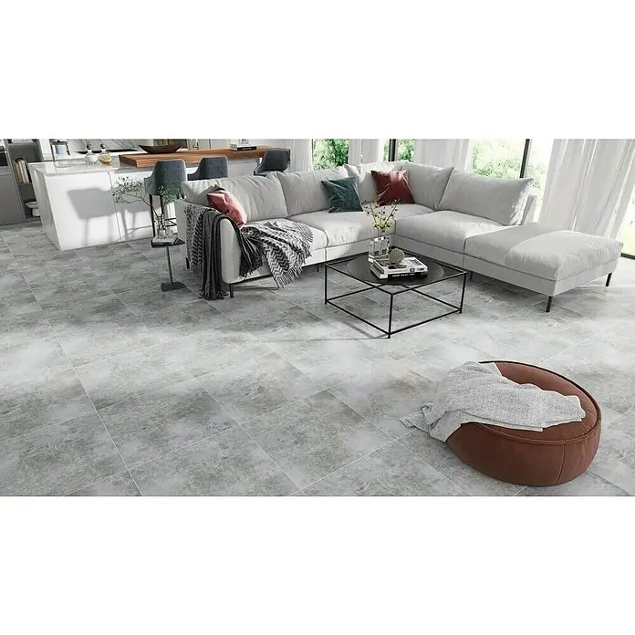 Feinsteinzeugfliese Luna Gris - 60 x 60 cm, Grau, Schimmernd - Ein modernes Wohnzimmer mit grauen Fliesen, einem stilvollen Sofa und einem eleganten Couchtisch. Die Fliesen verleihen dem Raum eine zeitlose Eleganz.