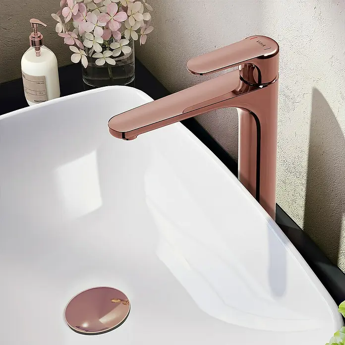 VitrA Waschtischarmatur Root Round - Höhe: 31,5 cm, Kupfer - Nahaufnahme eines modernen Waschbeckens mit elegantem, roségoldenen Wasserhahn und passendem Abflussstopfen.