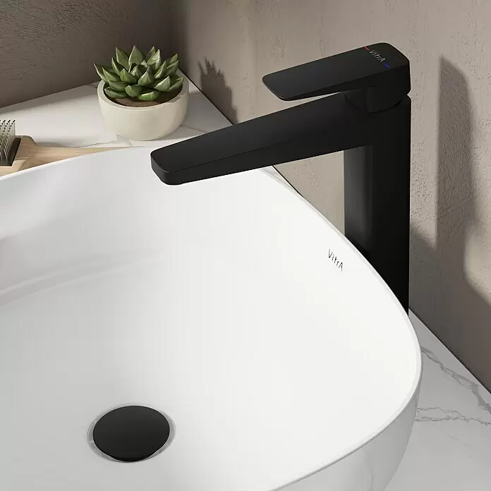 VitrA Waschtischarmatur Root Square - Höhe: 31 cm, Schwarz - Eine moderne, mattschwarze VitrA Armatur mit rot/blauen Anzeigen, installiert neben einem weißen VitrA Keramik-Aufsatzwaschbecken mit schwarzem Ablaufstöpsel.