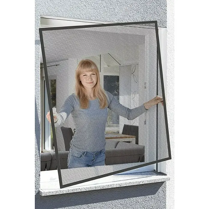 Schellenberg Mosquitera Action - An x Al: 120 x 140 cm, Montaje de la mosquitera: Inserción, Color bastidor: Antracita - Mujer instalando una mosquitera negra en una ventana.