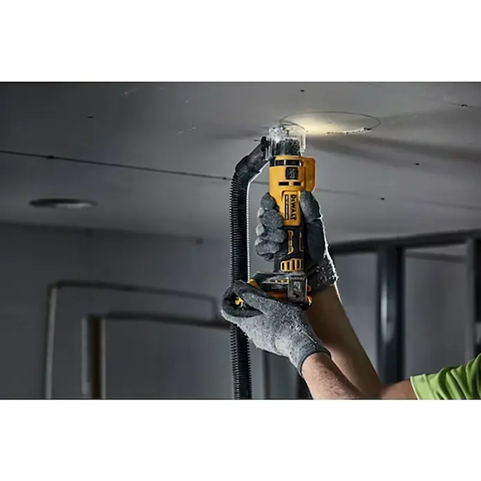 DeWalt XR 18V Sierra de sable de batería DCE555N-XJ - 18 V, Sin batería, Número de oscilaciones marcha en vacío: 26.000 r.p.m. - Un operario usa una herramienta DeWalt para cortar un agujero en un techo con una aspiradora para limpieza.