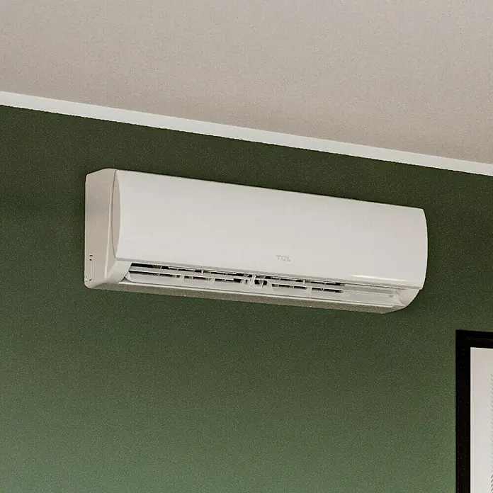 TCL Inverter-Klimasplitgerät TAC-18CHSD/TPG11 - Kühlleistung: 2.350 W - 5.900 W, Heizleistung: 6.080 W, Raumgröße: 52 m², Passend für: Räume bis ca. 52 m² - Nahaufnahme einer weißen TCL Klimaanlage, die an einer grünen Wand unter einer weißen Decke montiert ist.