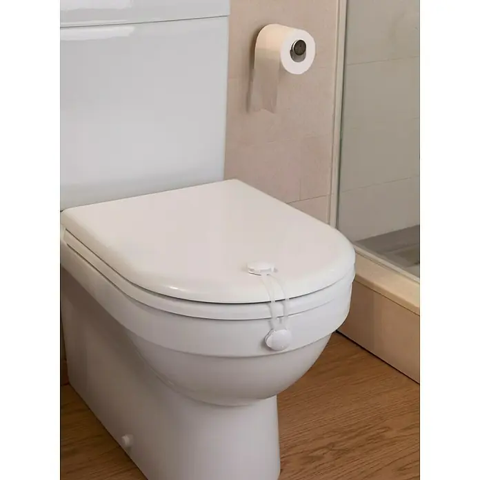 Inofix Cierre para muebles 5100-2- - Blanco, Tipo de montaje: Pegado - Un inodoro blanco con un cierre de seguridad para niños en la tapa y un rollo de papel higiénico en la pared.