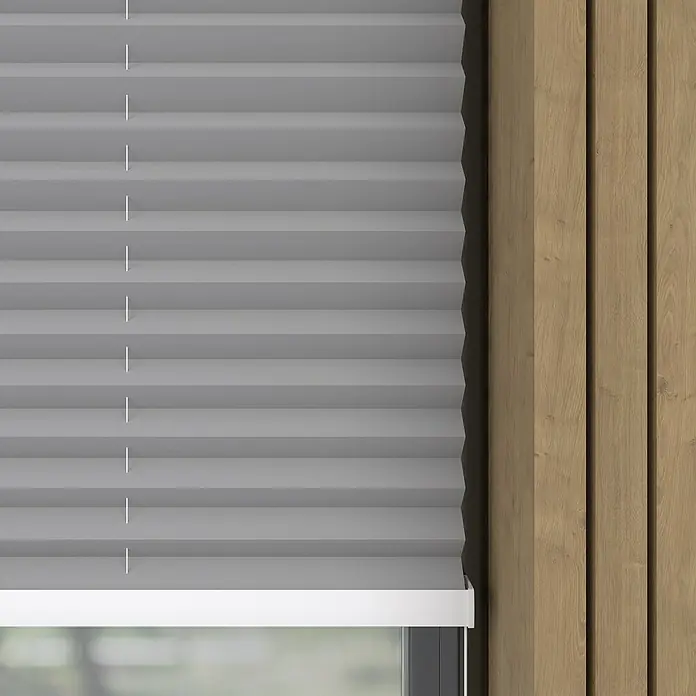 Expo Ambiente Plissee Thermo - B x H: 50 x 130 cm, Grau - Nahaufnahme von grauen Plissee-Jalousien, die ein Fenster bedecken, und einer hölzernen Wandverkleidung.