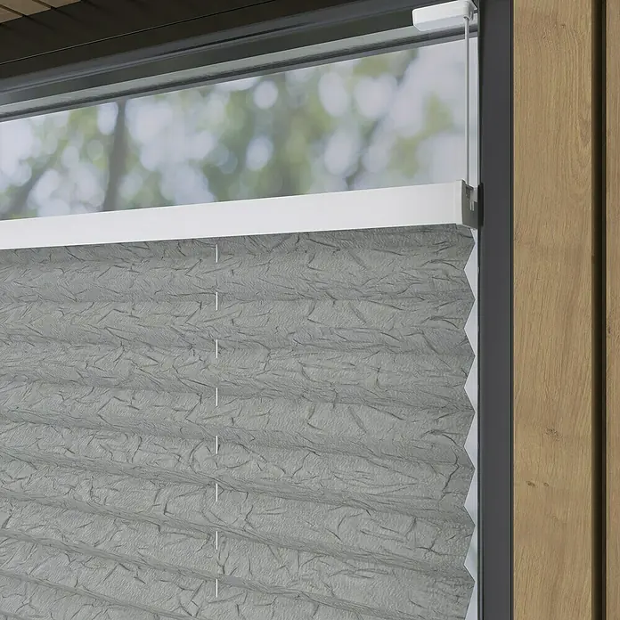 Expo Ambiente Plissee - B x H: 60 x 130 cm, Grau - Nahaufnahme einer grauen, horizontal gefalteten Plissee-Jalousie an einem Fenster, die für Privatsphäre und Lichtsteuerung sorgt.