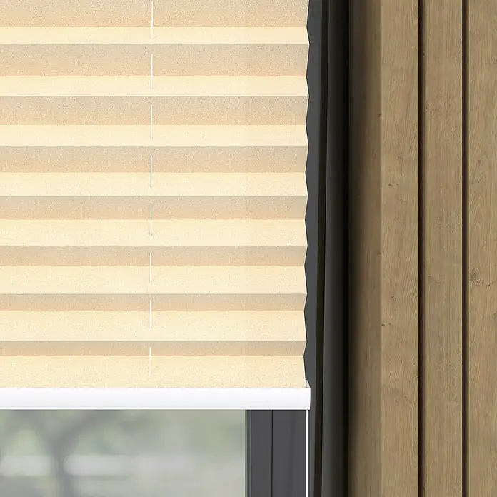 Plissee Basic VS TL - B x H: 60 x 130 cm, Creme - Nahaufnahme einer beigefarbenen Plissee-Fensterabdeckung, die einen modernen und eleganten Sonnenschutz bietet und das Licht sanft filtert.