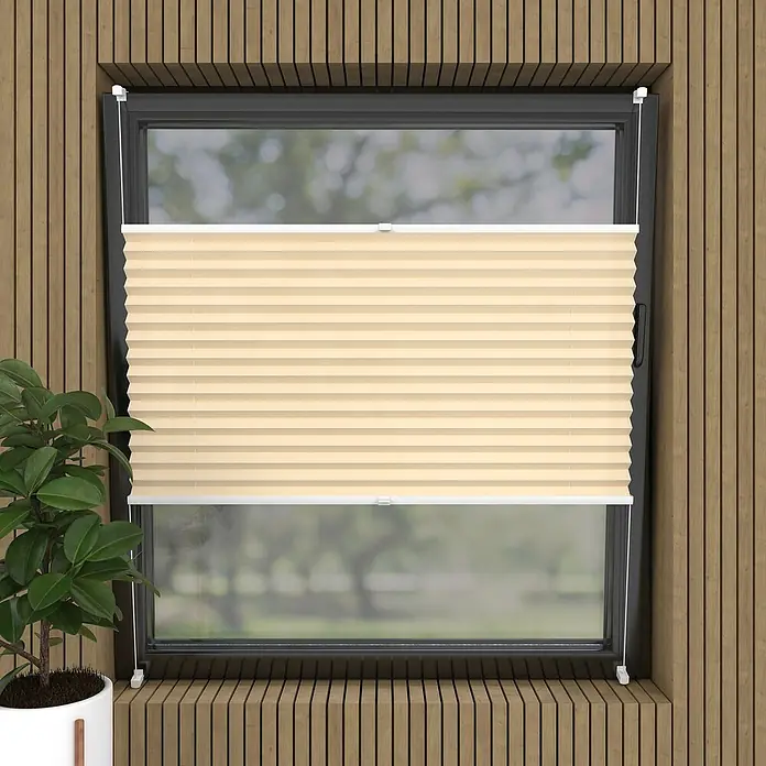 Plissee Basic VS TL - B x H: 60 x 130 cm, Creme - Nahaufnahme eines Fensters mit beigen, horizontalen Faltstores, die das Licht sanft filtern und eine ruhige Atmosphäre schaffen.