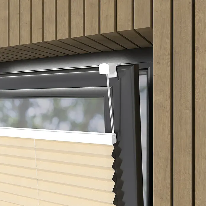 Plissee Basic VS TL - B x H: 60 x 130 cm, Creme - Detailaufnahme einer beigefarbenen Plissee-Jalousie an einem Fenster mit dunklem Rahmen, umgeben von Holzverkleidung.