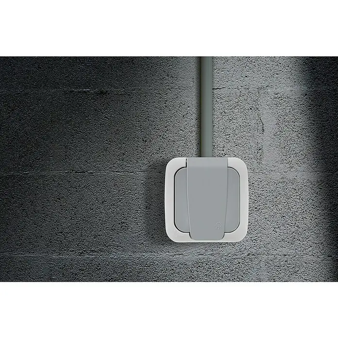 Siemens Delta IP54 Feuchtraum-Steckdose SIE028660 - 1-fach, IP54, Grau - Nahaufnahme einer grauen, wasserdichten Steckdose mit einem Rohr an einer Betonwand.