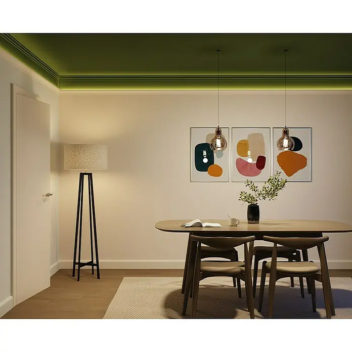 Nmc Decoflair Zierprofil CL11 - L x B x H: 2 m x 33 mm x 50 mm, Hochverdichtetes extrudiertes Polymer (HDPS) - Elegantes Esszimmer mit modernem Esstisch und stilvollen Stühlen, beleuchtet von einer Stehlampe und Pendelleuchten, die eine warme Atmosphäre schaffen.