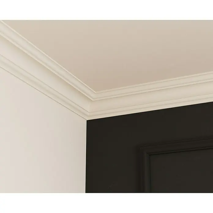 Nmc Decoflair Zierprofil Deckenleiste D10 - 2 m x 80 mm x 80 mm, Extrudiertes Polystyrol (XPS) - Nahaufnahme einer weißen Zierleiste an der Decke, die sich an einer Wand in einem Raum mit dunkler Akzentwand befindet.