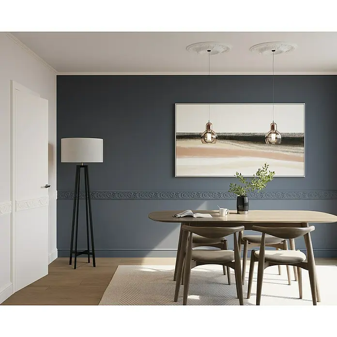 Nmc Decoflair Zierprofil Deckenleiste D3 - 2 Stk., 2 m x 33 mm x 33 mm, Extrudiertes Polystyrol (XPS) - Elegantes Esszimmer mit einem Holztisch und Stühlen, beleuchtet von stilvollen Pendelleuchten und einer Stehlampe, alles vor einer dunkelblauen Wand.