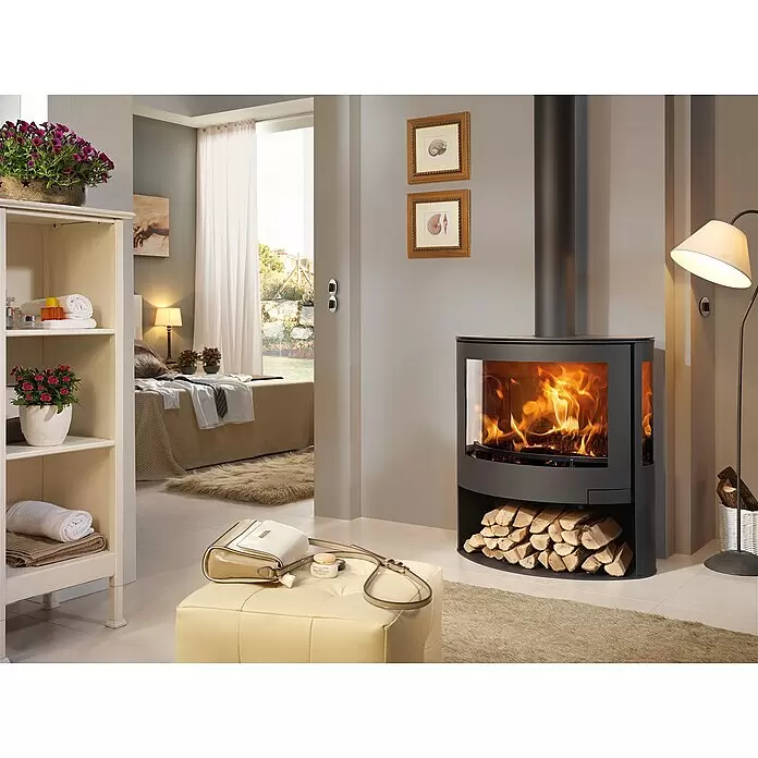 Panadero Estufa de leña Iris - 7,8 kW, Volumen de calefacción: 240 m³, Negro - Chimenea de leña negra moderna con puerta de cristal y llamas vivas, con leñero integrado, en un salón elegante.