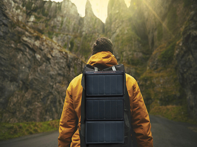 Reisender mit mobiler Solaranlage als Rucksack