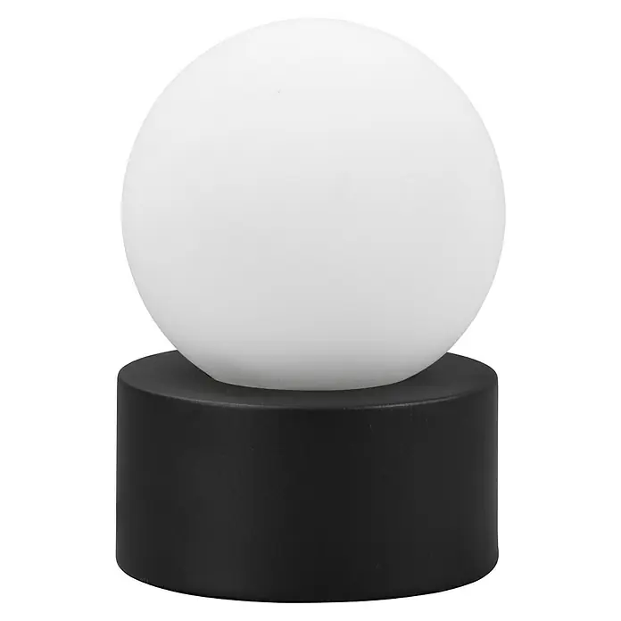 Reality Leuchten Tischleuchte rund Countess - Ø x H: 12 x 17 cm, 25 W, Schwarz matt, Weiß, E14 - Diese Aufnahme zeigt eine moderne Tischleuchte mit einer weißen Kugellampe auf einem zylindrischen, schwarzen Sockel.