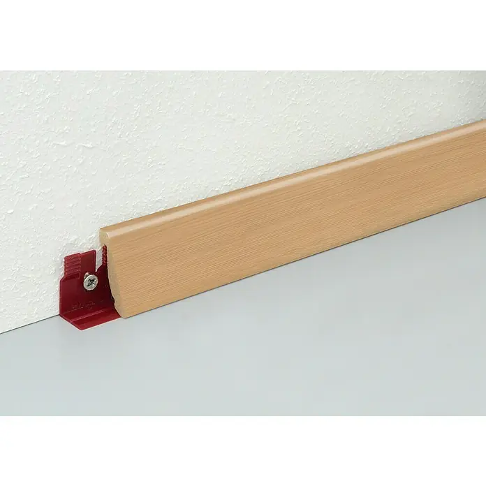 Profiles and more Sockelleiste FU147H - 2.400 x 18,5 x 38,5 mm, Vollholz, Farbe: Homerun - Sockelleiste in Holzoptik, befestigt mit einem roten Montageclip an einer weißen Wand, ideal für moderne Innenräume.