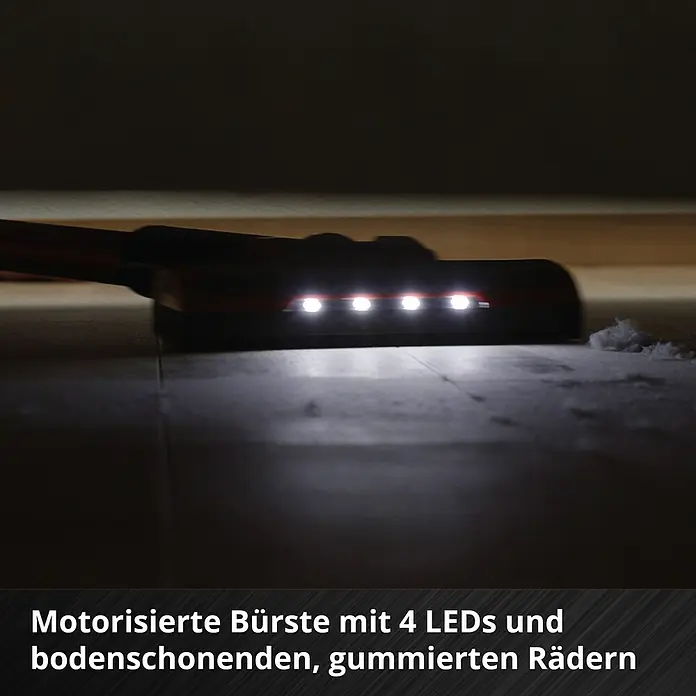 Einhell Power X-Change 18V Akku-Staubsauger TE-SV 18 Li-Solo - 18 V, Ohne Akku, Behältervolumen: 0,6 l - Bürste mit 4 LEDs, die den Boden schont und gummierte Räder hat, im Einsatz unter einem Möbelstück.