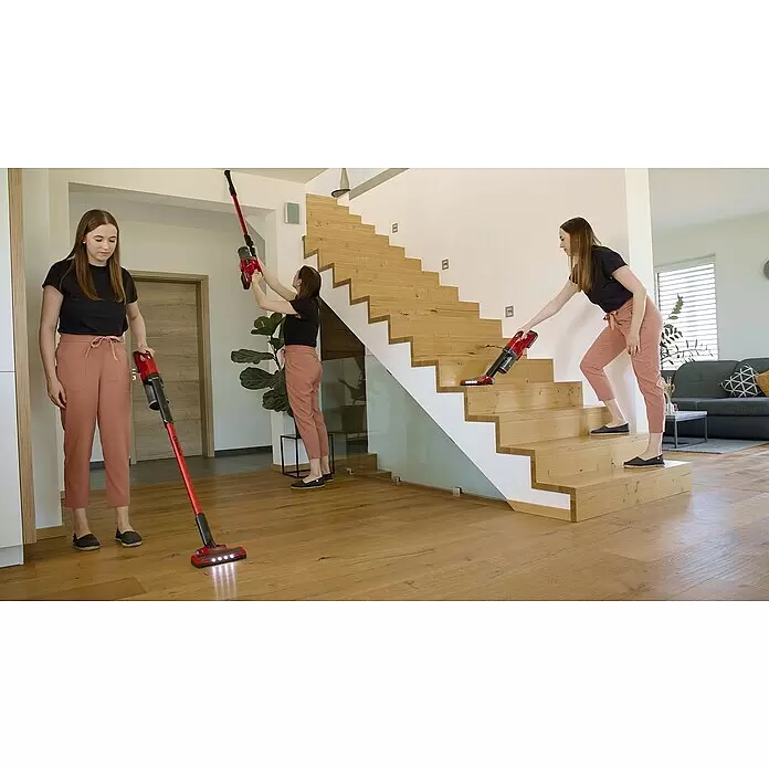 Einhell Power X-Change 18V Akku-Staubsauger TE-SV 18 Li-Solo - 18 V, Ohne Akku, Behältervolumen: 0,6 l - Roter Akku-Stielstaubsauger, von einer Frau zum Reinigen von Böden, Treppen und hohen Bereichen in einem modernen Zuhause verwendet.
