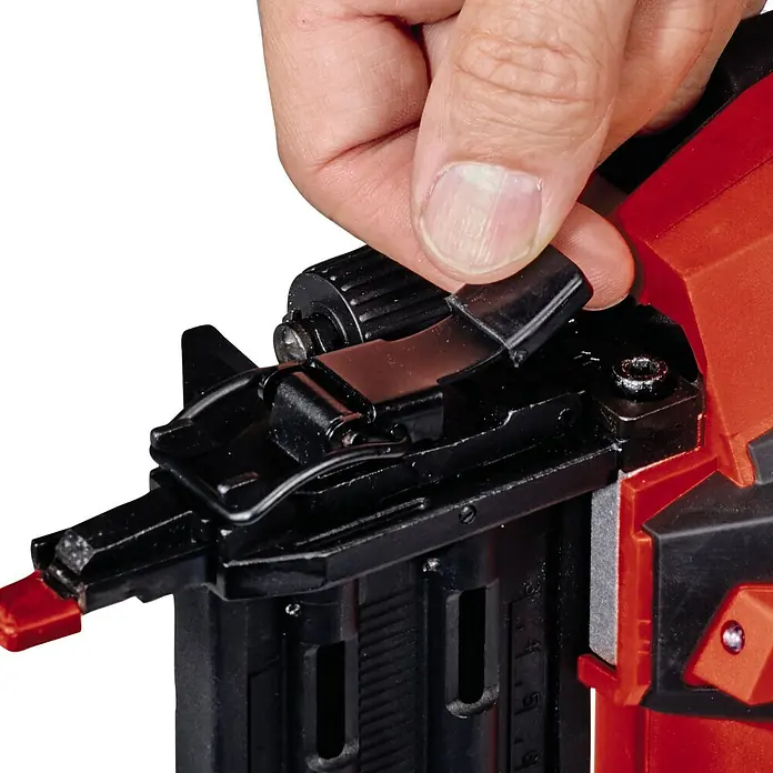 Einhell Professional PXC 18V Clavadora de batería FIXETTO 18/50 N - 18 V, Sin batería, Longitud del clavo: 15 mm - 50 mm - Primer plano de una mano accionando una palanca negra en una clavadora inalámbrica roja Einhell.