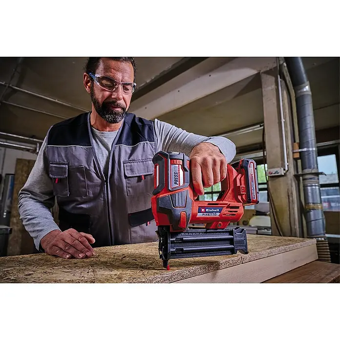 Einhell Professional PXC 18V Clavadora de batería FIXETTO 18/50 N - 18 V, Sin batería, Longitud del clavo: 15 mm - 50 mm - Un hombre opera una clavadora inalámbrica Einhell FIXETTO, una herramienta diseñada para la fijación rápida y precisa de materiales.