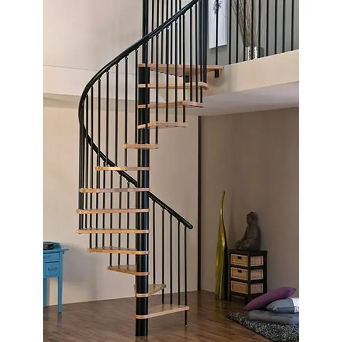 Sogem Escalera de caracol Kappa - Diámetro: 140 cm, Negro, Color peldaños: Haya barnizada, Altura de planta: 309 cm - Una elegante escalera de caracol con barandillas de metal negro y peldaños de madera clara, situada en un espacio de estar elegante.