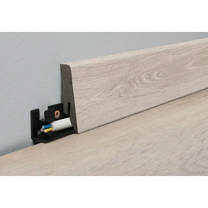 LOGOCLIC Aquaprotect Smart Silent Sockelleiste K58C Lombok Oak - 2,6 m x 18 mm x 58 mm, HDF - Nahaufnahme einer Sockelleiste mit integriertem Kabelschacht, die eine saubere Kabelführung ermöglicht und das Erscheinungsbild aufwertet.