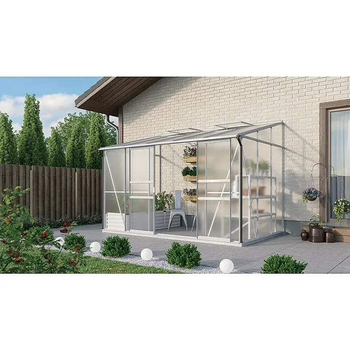 Vitavia Gewächshaus Osiris 6500 - Außenmaß inkl. Dachüberstand (B x T): 324,3 x 201 cm, 4 mm, Aluminium - Das Bild zeigt ein Gewächshaus aus Polycarbonat, das an ein Haus angebaut ist. Es gibt Pflanzenregale und eine Vielzahl von Pflanzen darin.