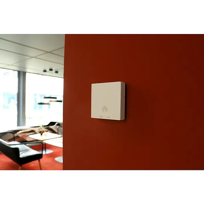UniTEC Kohlenmonoxidmelder Design WS - L x B x H: 50 x 120 x 150 mm, Batterielaufzeit: 10 Jahre - Nahaufnahme eines weißen, quadratischen Smart Home Geräts an einer roten Wand, mit den Aufschriften "Power" und "Fault".