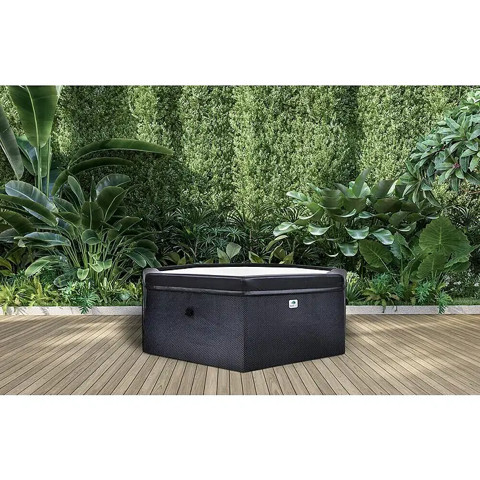 GardWell Mobil-Whirlpool Unos - Ø x H: 193 x 70 cm, Anthrazit/Innen Weiß, 1.000 l - Ein luxuriöser, sechseckiger Whirlpool mit schwarzem Netzgewebe und weissen Innenfläche auf einer hölzernen Terrasse, umgeben von üppigem Grün.