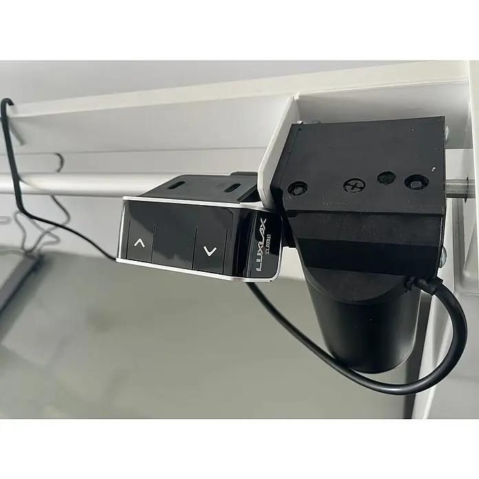 Bastidor de mesa T800 - Elevable, Blanco, Acero, Display digital y USB, Capacidad de carga: 80 kg - Primer plano de una unidad de control de persianas LUXLAX con botones y motor, montada en una estructura de ventana blanca.