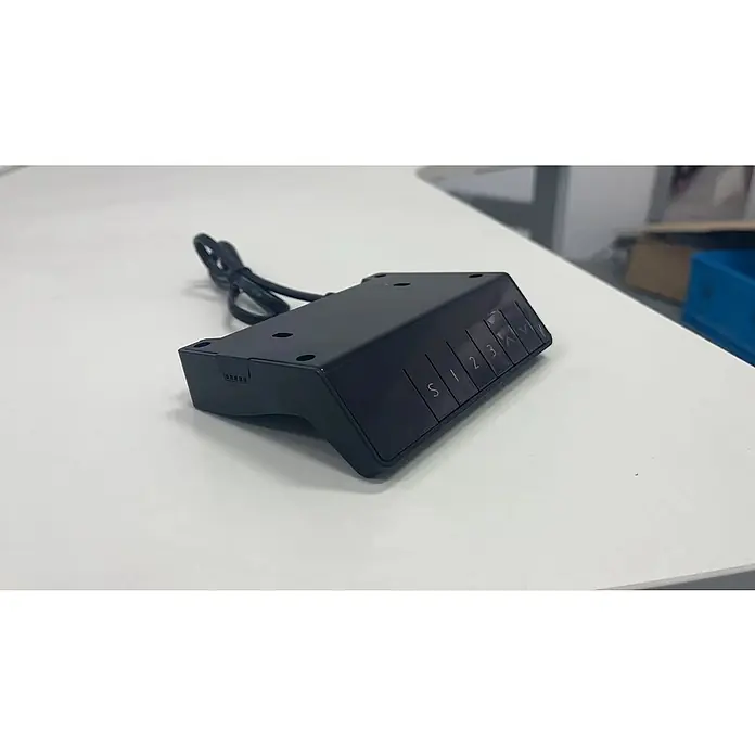 Bastidor de mesa T1000 - Elevable, Blanco, Acero, Display digital y USB, Capacidad de carga: 100 kg - Primer plano de una unidad de control negra con varios botones, situada sobre una superficie blanca y conectada a un cable.