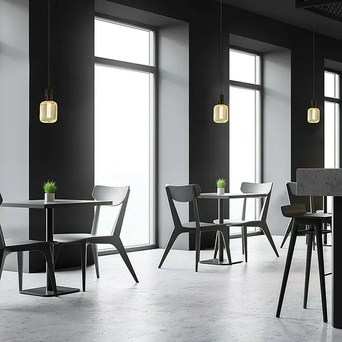 Searchlight LED-Lampe Zylinder Filigran - E27, Dimmbar, Bernstein, 120 lm, 3,5 W, Gold - Ein heller, moderner Café-Innenraum mit stilvollen Tischen, Stühlen und Pendelleuchten. Das Design ist minimalistisch und einladend.
