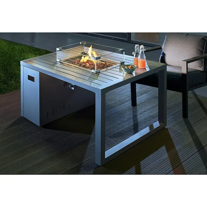 Buschbeck Feuerstelle - 75 x 115 x 58,5 cm, Stahl - Ein moderner Gasfeuertisch mit Windschutz, Getränken und Snacks auf einer Terrasse. Perfekt für gemütliche Abende im Freien.