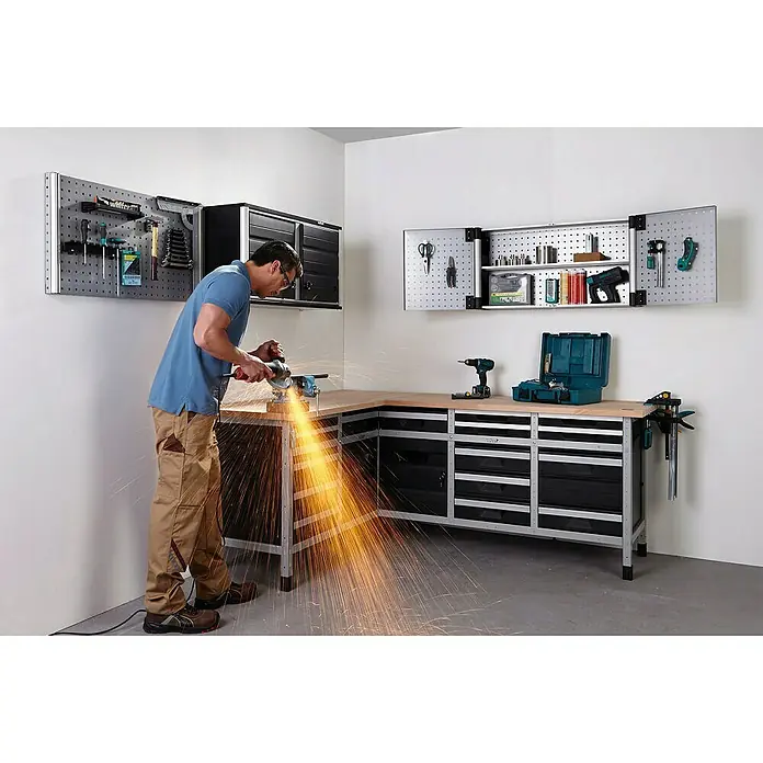 Wolfcraft Armario alto de taller - L x An x Al: 98,5 x 50 x 30 cm, Número de puertas: 2 ud., Tipo de montaje: Colgar - Escena de taller con un hombre trabajando en un banco, chispas, herramientas y armarios al fondo.