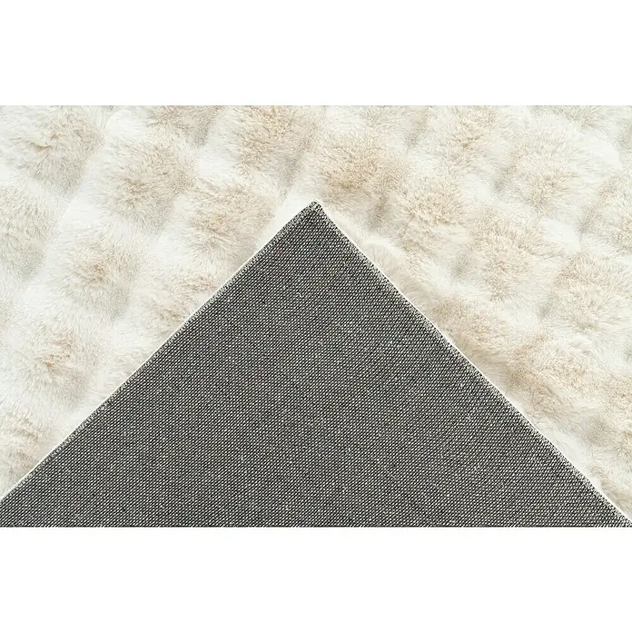Hochflorteppich Harmony - Ivory, 170 x 120 cm, 100 % Polyester (Flor) - Nahaufnahme eines flauschigen, hellen Teppichs mit einer grauen, gewebten Rückseite, die einen Kontrast zur weichen Oberseite bildet.