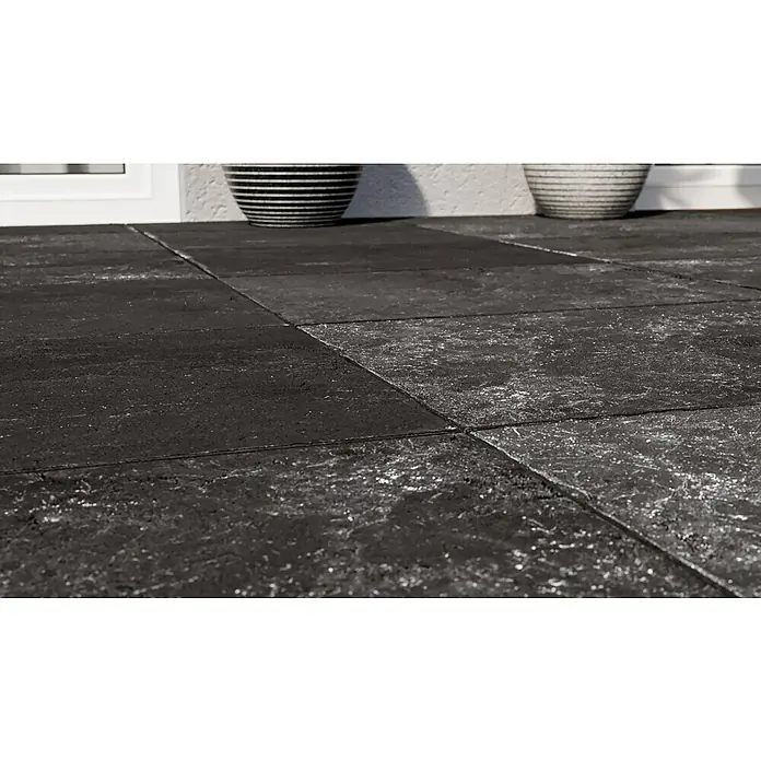 Terrassenfliese Cera 2.0 - 40,8 x 60,1 x 2 cm, Antiquus Carbon, Matt - Nahaufnahme von modernen dunklen Bodenfliesen mit feiner Textur. Zwei dekorative Schalen im Hintergrund ergänzen das Gesamtbild des Bodenbelags.