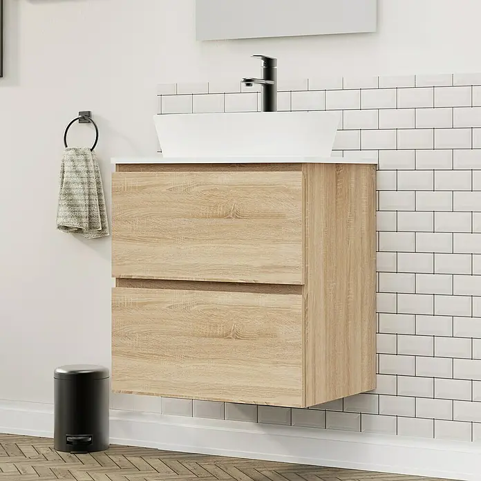 Artysan Conjunto de mueble de baño Troy - Ancho: 60 cm, Natural, 4 pzs. - Primer plano de un moderno tocador con textura de madera y lavabo sobre encimera blanco sobre una pared de azulejos blancos tipo metro.