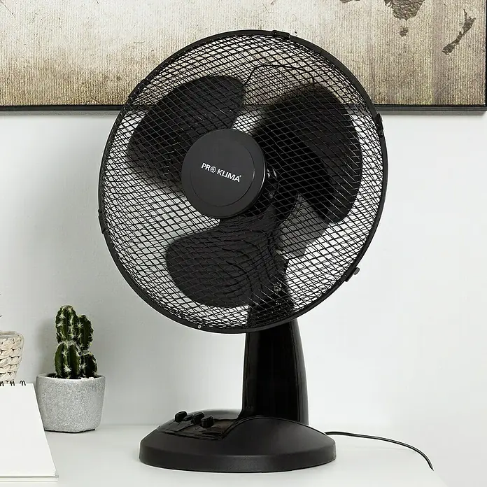 Voltomat Tischventilator - Schwarz, 30 cm - Das Bild zeigt einen schwarzen "Pro Klima" Tischventilator mit einem runden Gitter und drei Rotorblättern auf einem weißen Tisch.