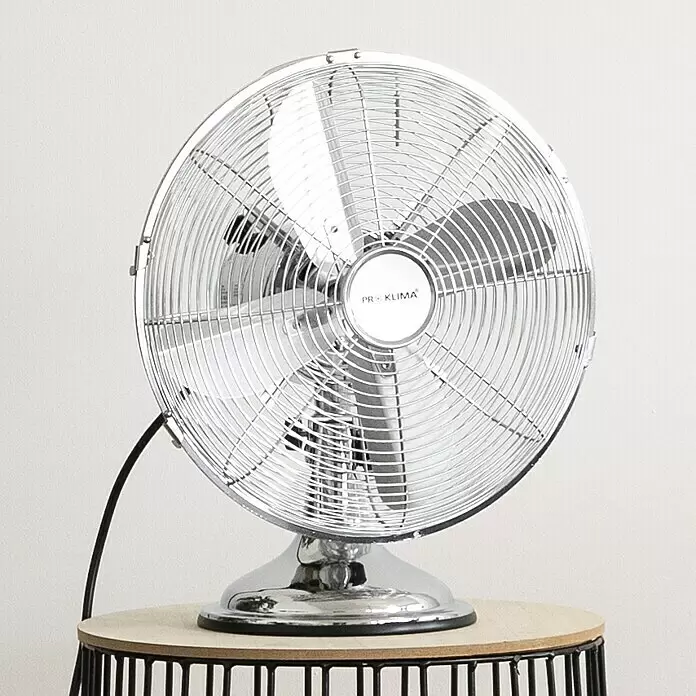 Voltomat Tischventilator - Silber, 30 cm - Eleganter, verchromter Tischventilator im Retro-Stil mit glänzendem Metallfinish, auf einem Holztisch stehend.