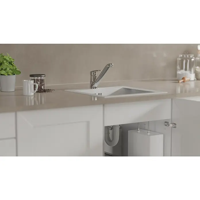 Camargue Spültischarmatur Grande - Niederdruck, Glänzend - Nahaufnahme einer modernen weißen Küchenspüle mit einem glänzenden Chromhahn, eingebaut in eine helle Arbeitsplatte. Unter dem Spülbecken befindet sich Stauraum.