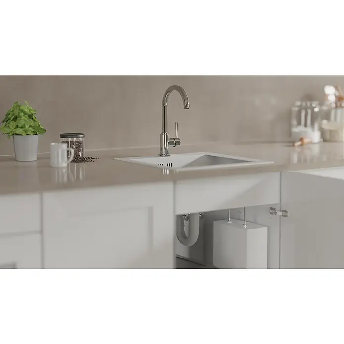 Camargue Merida Spültischarmatur - Niederdruck, Chrom - Ein Waschbecken mit Wasserhahn in einer modernen Küche mit weißem Unterschrank, der die Rohrleitungen und den Wasserbehälter verbirgt.