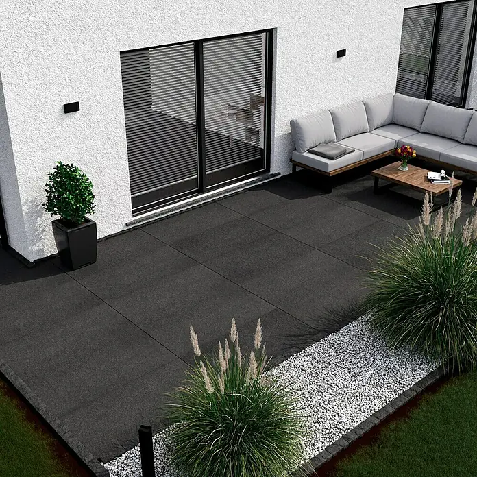 Terrassenfliese Basalt 2.0 - 59,7 x 119,7 x 2 cm, Basaltgrau, Matt - Bild einer Außenterrasse mit dunklen Terrassenplatten, Gartenmöbeln und dekorativen Pflanzen. Die Terrassenplatten sind das Hauptmerkmal.