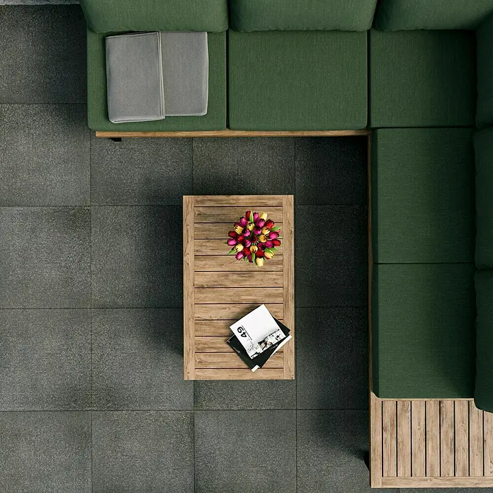 Terrassenfliese Basalt 2.0 - 59,7 x 59,7 x 2 cm, Basaltgrau, Matt - Top-Ansicht eines grünen Sofas und eines Couchtisches mit Blumen und Zeitschriften auf einem grauen Fliesenboden.