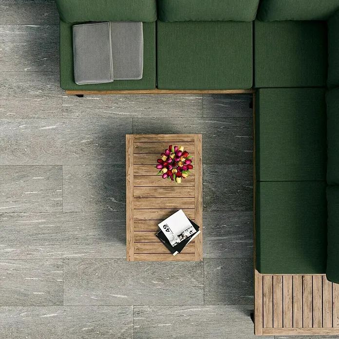 Esterno 20 T by Palazzo Terrassenfliese Davos - 40 x 120 x 2 cm, Greige, Matt - Draufsicht auf ein modernes Wohnzimmer mit grüner Eckcouch, Holztisch mit Blumen und Zeitschriften auf einem grauen Steinboden.