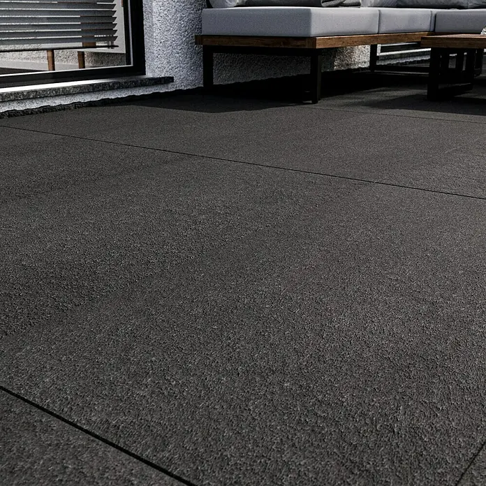 Terrassenfliese Basalt 2.0 - 59,7 x 119,7 x 2 cm, Basaltgrau, Matt - Nahaufnahme von dunklen Terrassenfliesen, die eine moderne und stilvolle Außenfläche schaffen. Perfekt für zeitgenössische Designs.